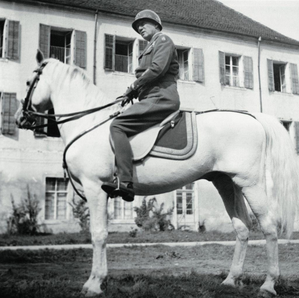 General Patton je bil velik ljubitelj konj in preizkušen jezdec. V okviru ameriške reprezentance je leta 1912 nastopil v modernem pentatlonu celo na olimpijskih igrah na Švedskem. Na sliki jezdi žrebca »Favory Africa«, enega najbolj znanih lipiških žrebcev. Adolf Hitler ga je nameraval po koncu vojne podariti japonskemu cesarju Hirohitu. (vir: US National Archives)